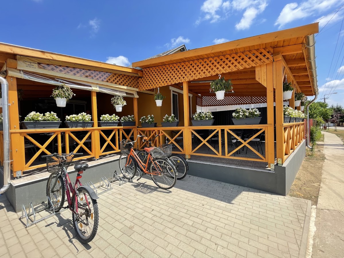 Az étterem külső nézete fa pergolával és virágládákkal